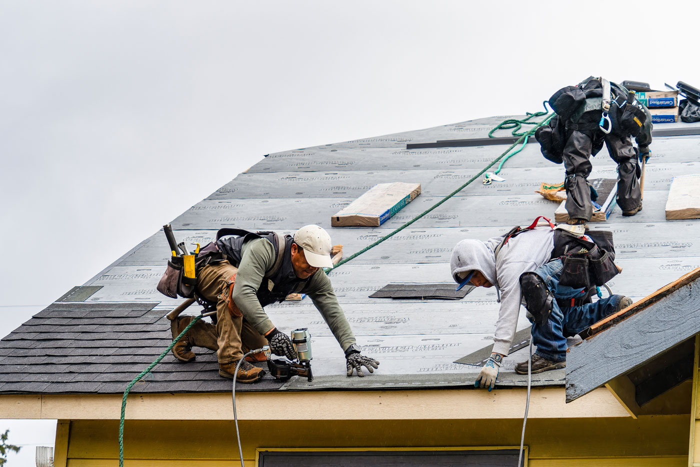 Crew of workers installing a new roof on a house